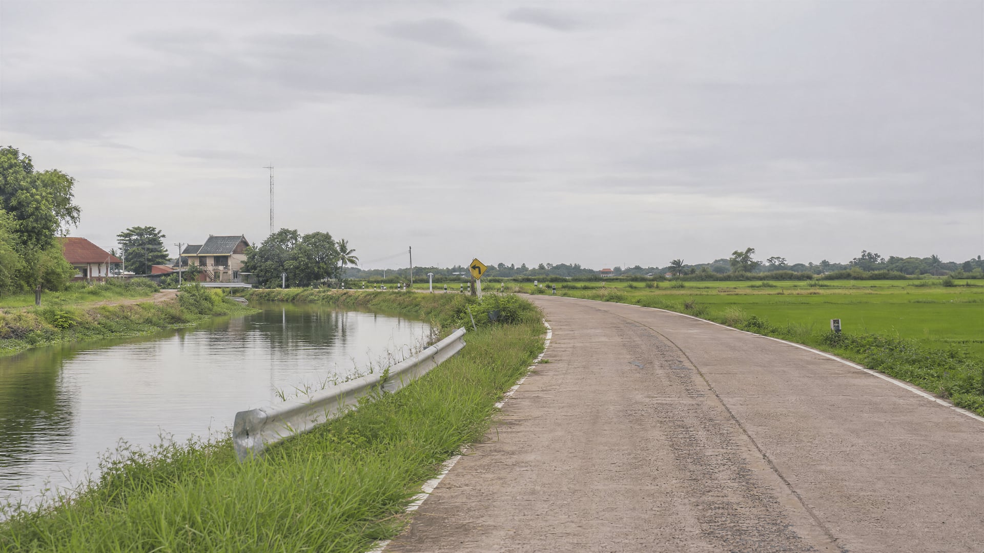 Canal-side farm road leading toward rice fields in Bang Ban, Ayutthaya