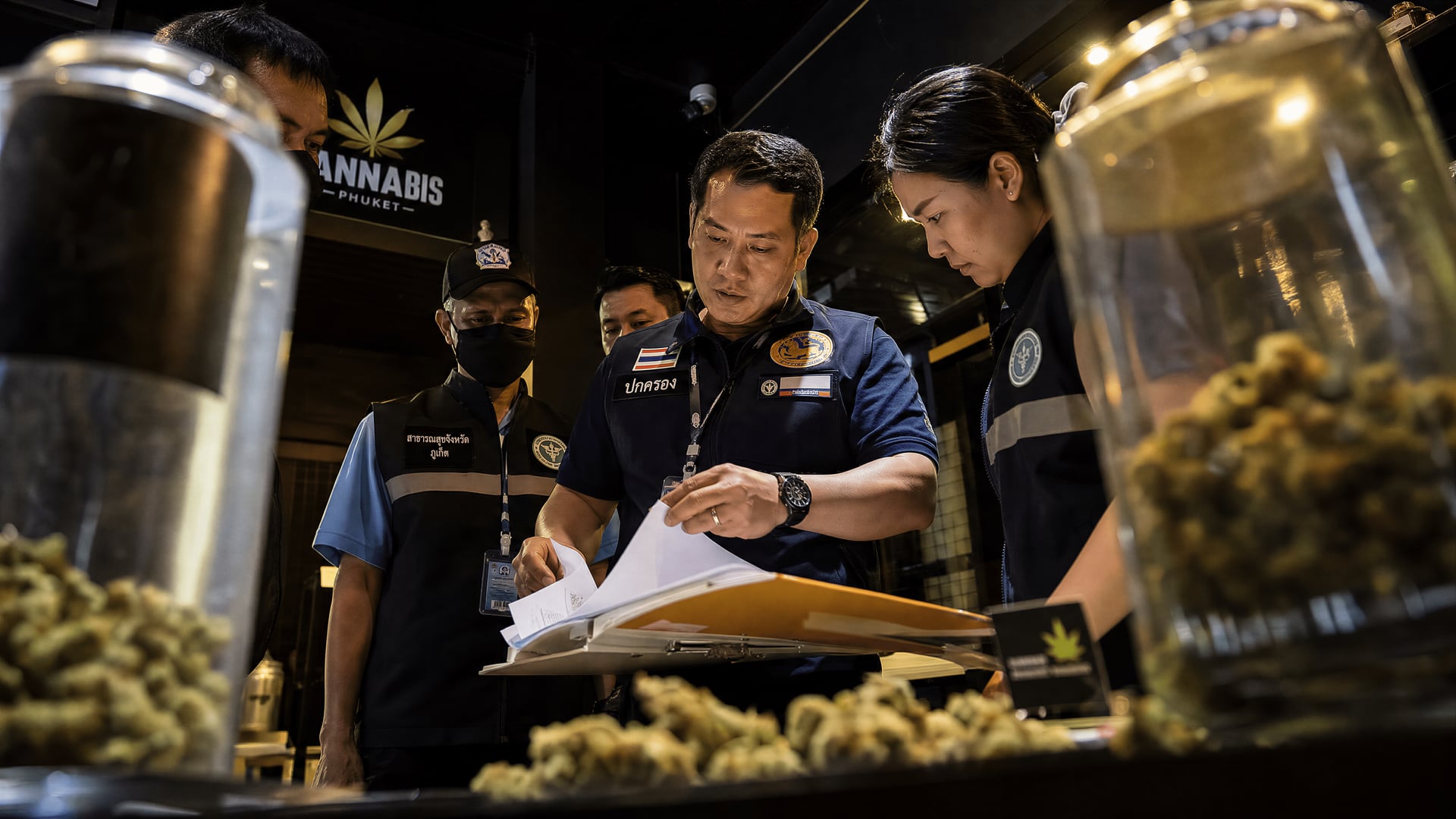Provincial officials inspect a cannabis shop's licence documents in Phuket Old Town